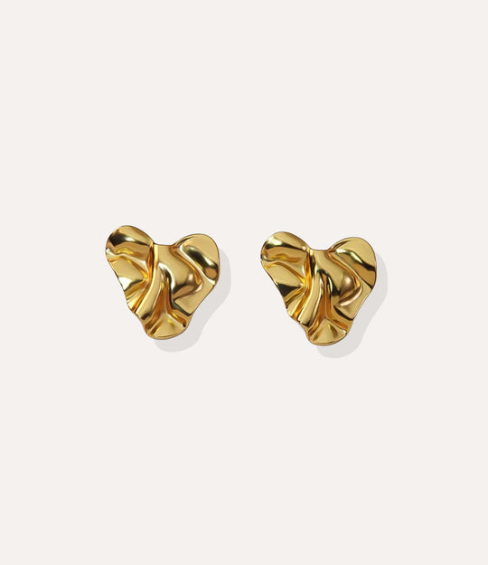 Close up of the Hammered Heart Stud earrings in gold highlighting the textured hammered finish and heart shape.