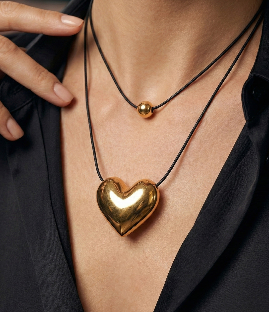 Woman wearing a gold heart-shaped necklace with a blurred background