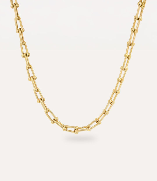 Gold beaded-link chain necklace featuring U-shaped interconnected links on a cream background