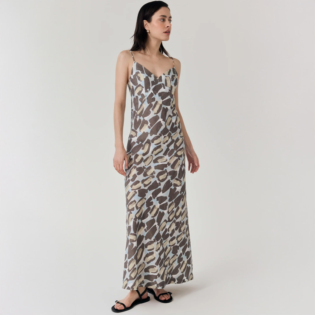 Woman wearing a long, patterned dress on a white background