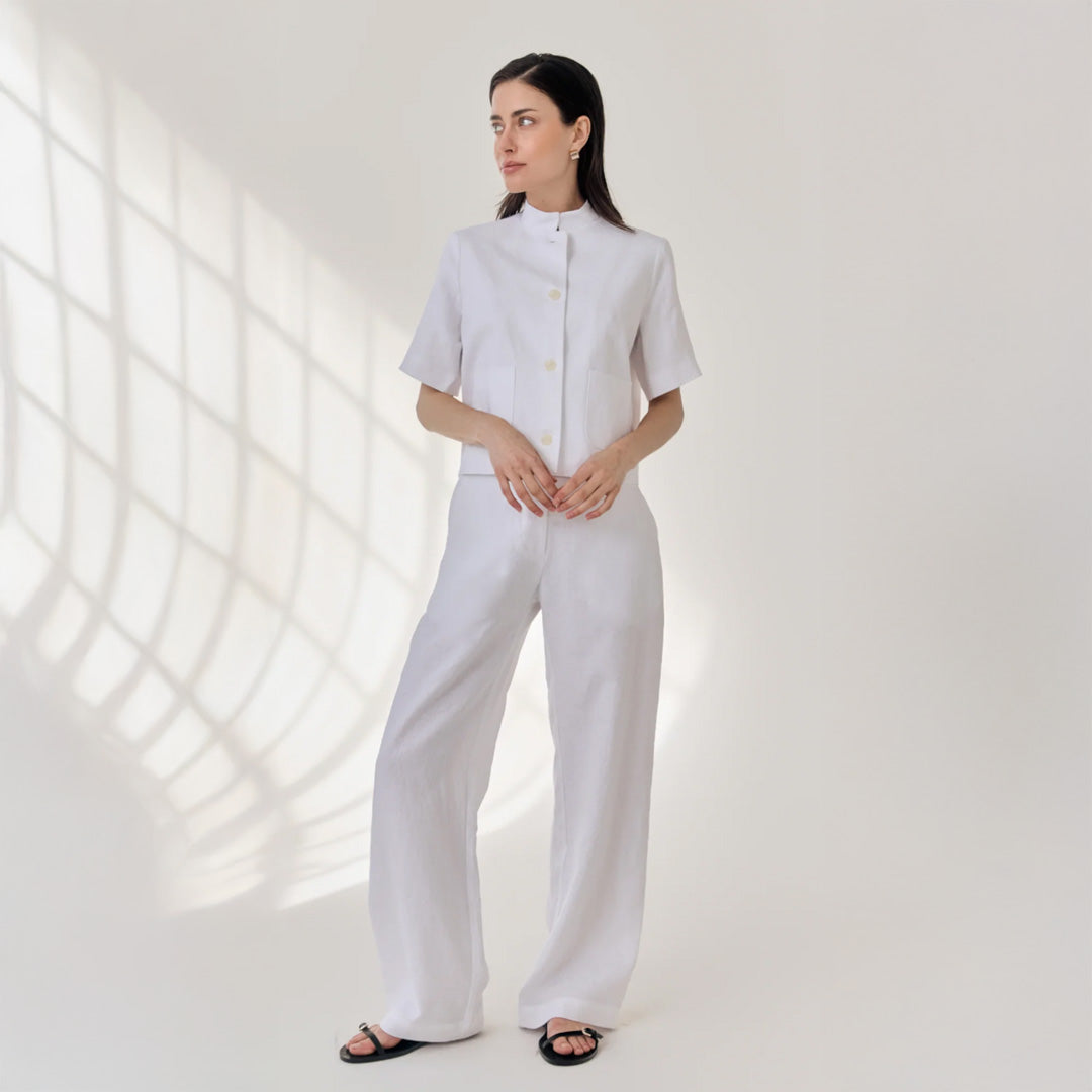 Woman wearing a white outfit with a light background