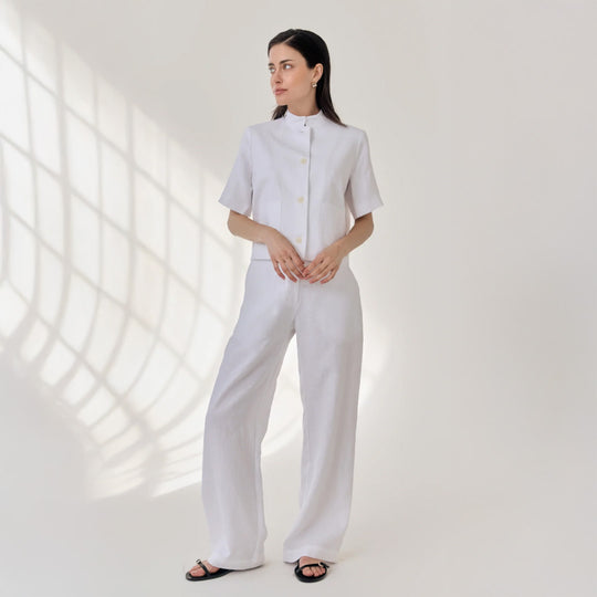 Woman wearing a white outfit with a light background