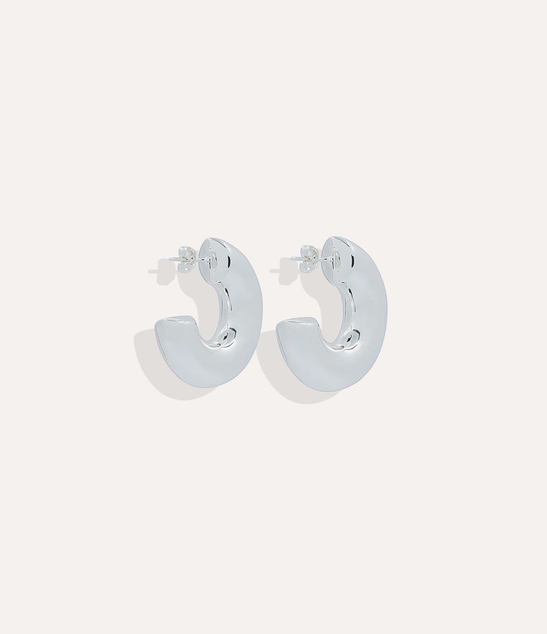 Product shot of the Lola Hoops in sterling silver showing the cool metallic tone and wide classic silhouette on a white background.