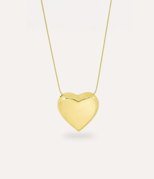 Gold heart-shaped pendant on a chain against a white background