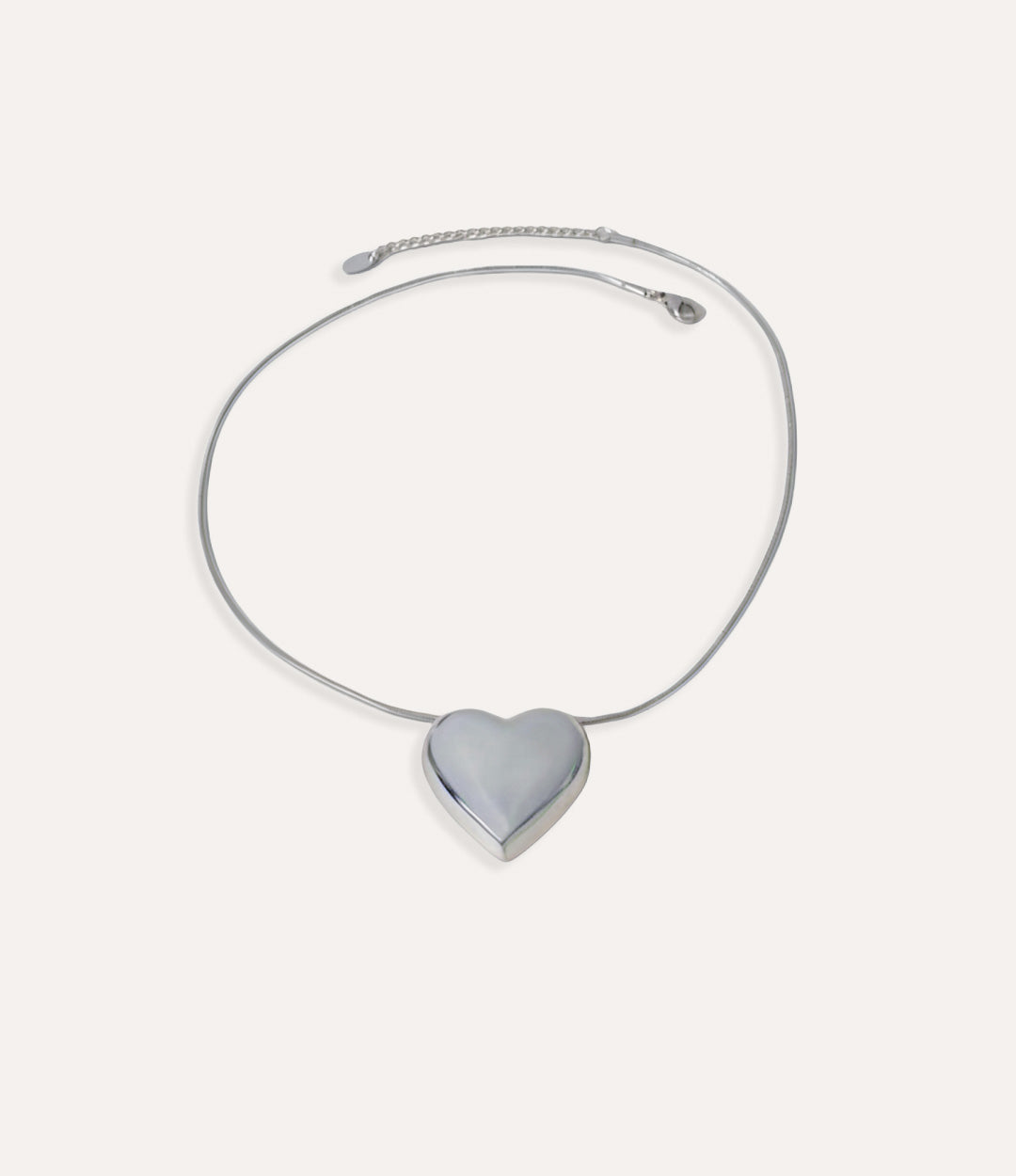 Silver necklace with a heart-shaped pendant on a white background
