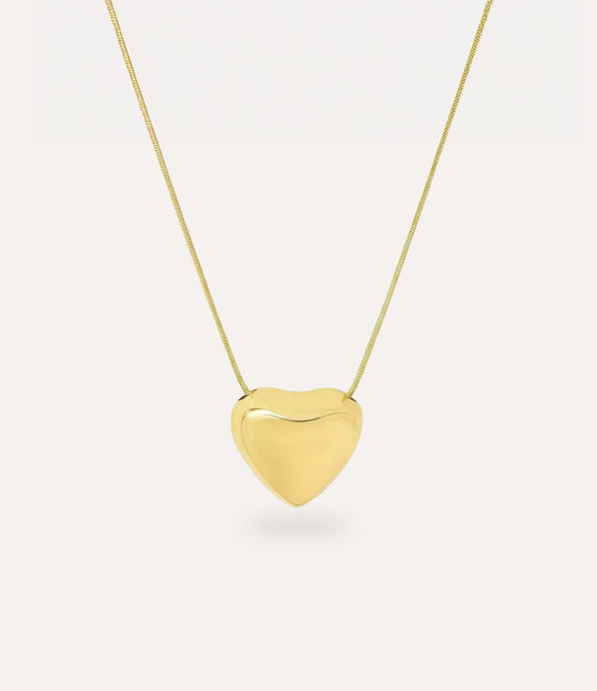 Gold heart-shaped pendant on a chain against a white background