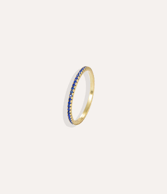 Gold ring with blue stones on a white background