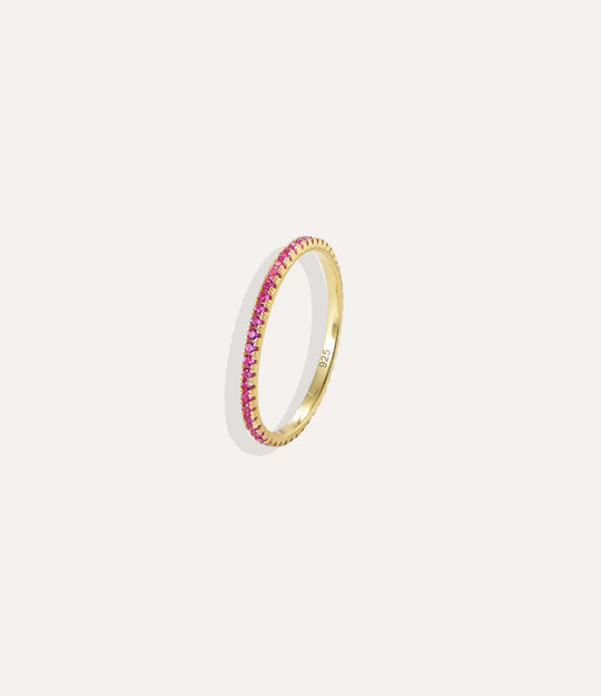 Gold ring with pink gemstones on a white background