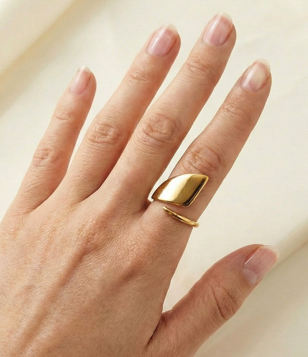 Model wearing Mod Ring in 18k gold plated finish, featuring a smooth, substantial statement design made of waterproof stainless steel, isolated on plain background.