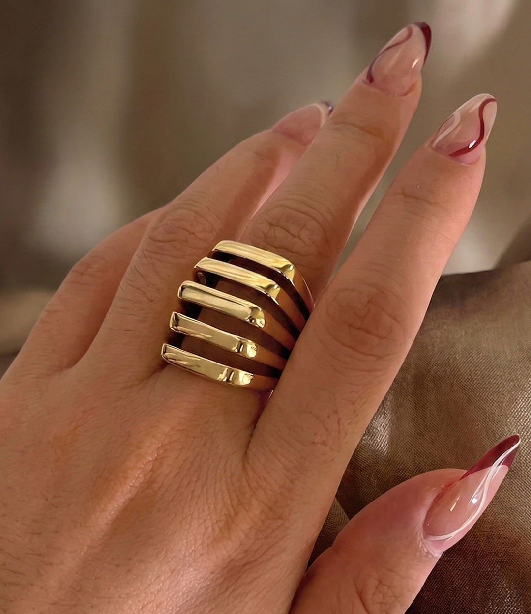 Woman's hand modeling the Mod Stack Ring in gold on the middle finger, showcasing the bold geometric shape and multi-stack illusion.