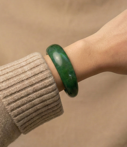 Woman wearing green acrylic resin bangle with irregular sculptural shape