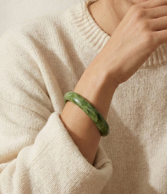 Woman wearing green acrylic resin bangle with irregular sculptural shape