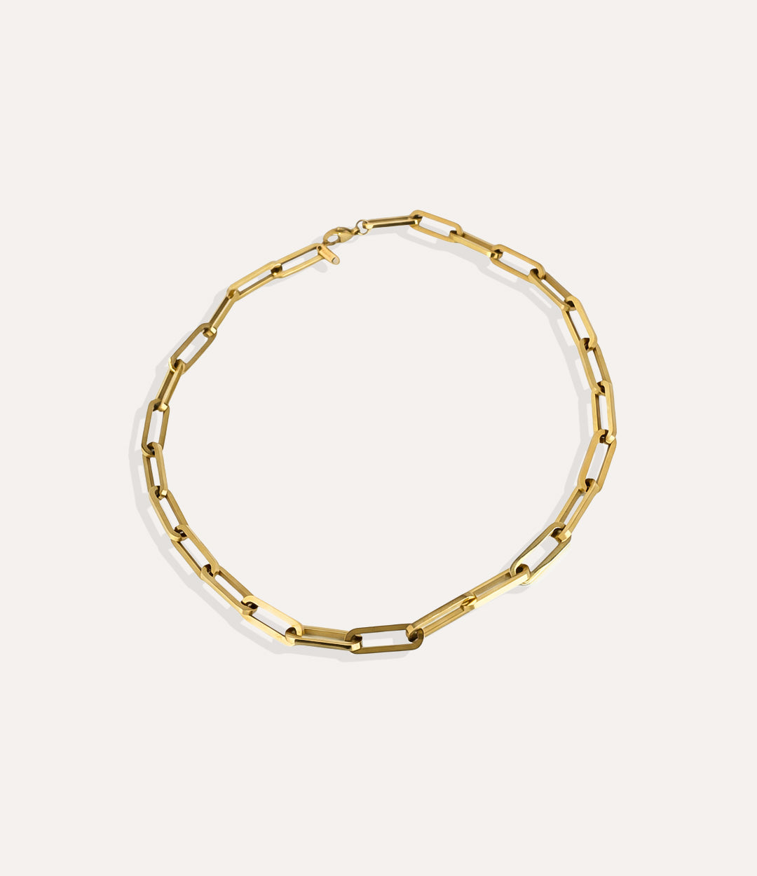 Oversized gold paperclip necklace crafted in 14k gold plated stainless steel on a neutral background