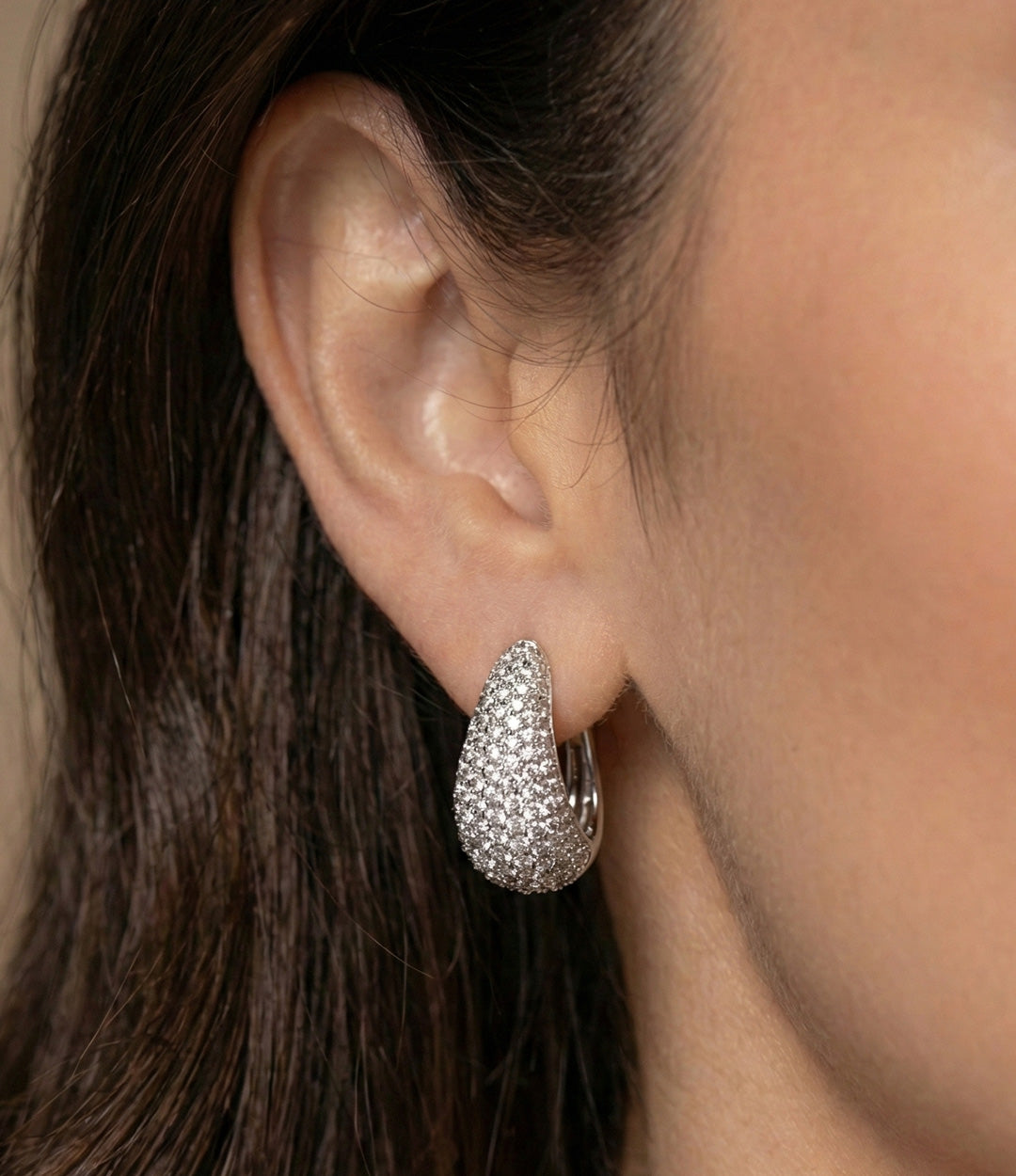 Close up of a model wearing the Pave Diamond Tear Drop Earring in silver showing the elegant drop shape and sparkling pave details against a neutral background.