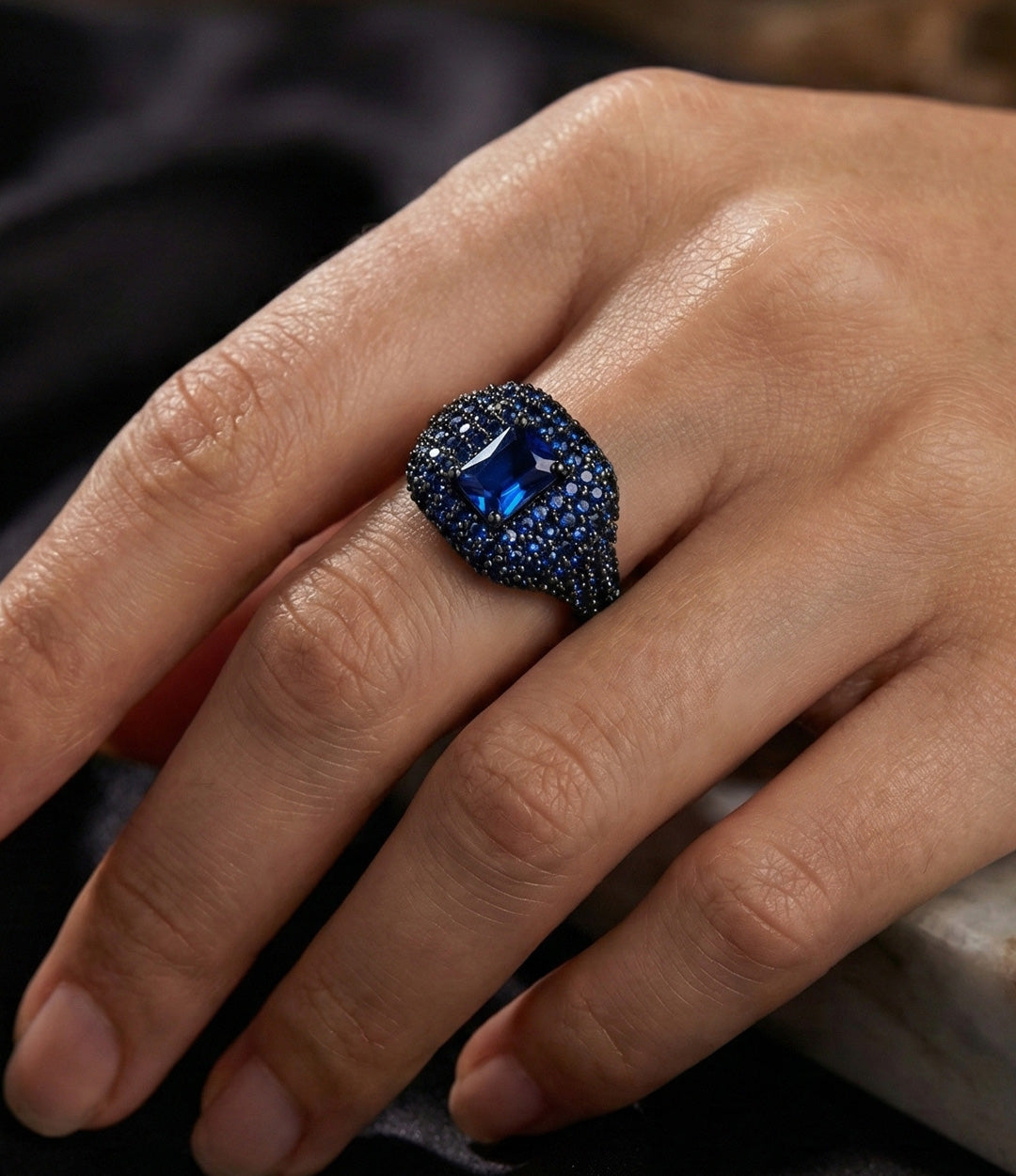 Woman's hand wearing the Adjustable Pave Signet Ring, showcasing the vibrant colorful stones and funky style on the index finger.
