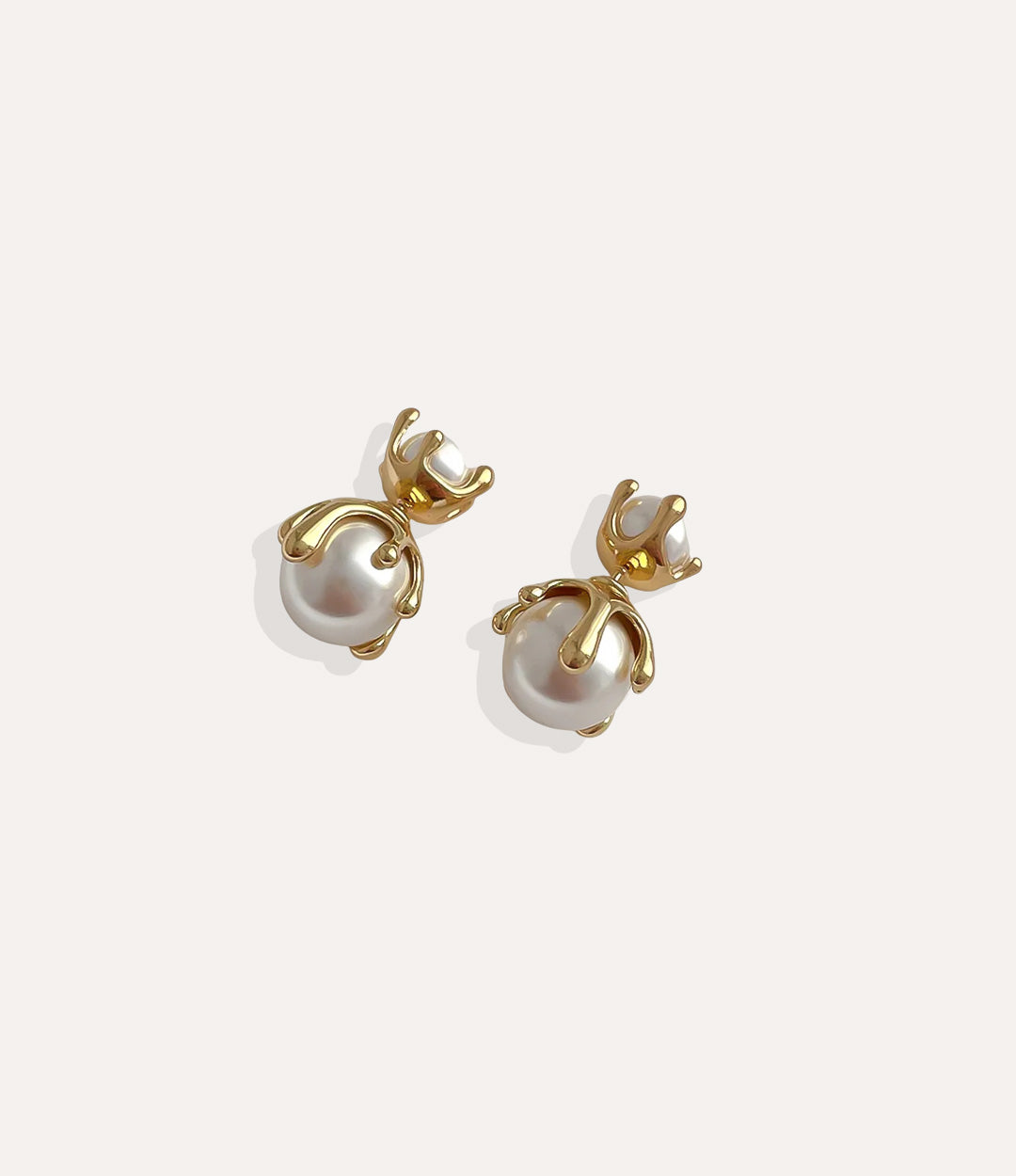 Close up of Pearl Drip Stud earrings in gold highlighting the sleek drip design and pearl accent.