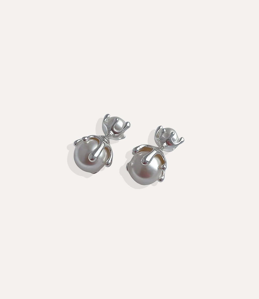 Close up of Pearl Drip Stud earrings in silver showcasing the contemporary drip shape and classic pearl detail.