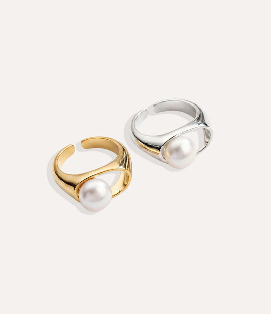 Two pearl rings, one gold and one silver, on a white background