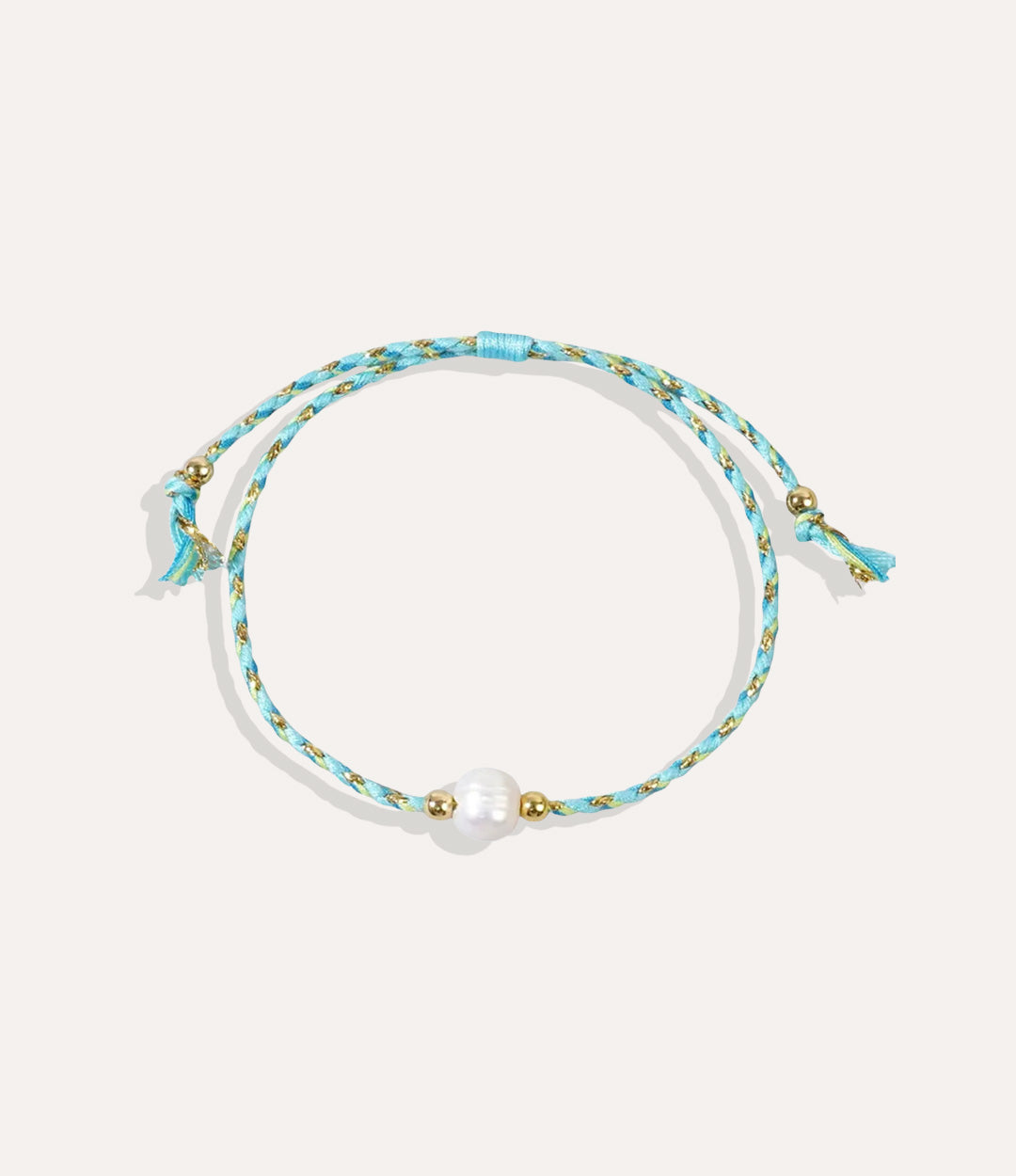 Pearl on a turquoise string bracelet displayed on a neutral background showcasing its vibrant cord and glossy pearl.