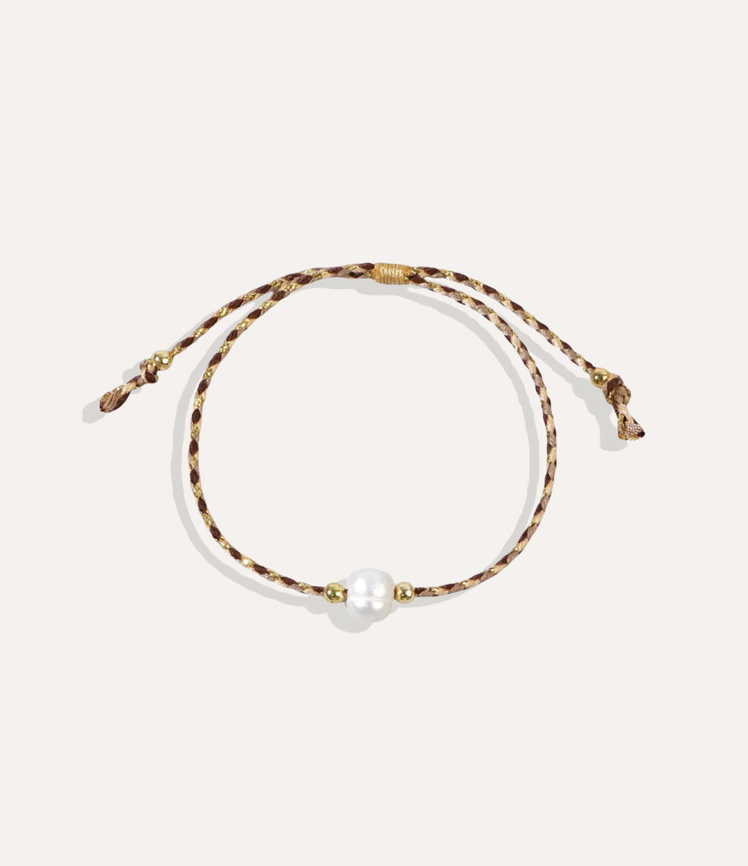 Pearl on a brown string bracelet displayed on a neutral background showcasing its vibrant cord and glossy pearl.