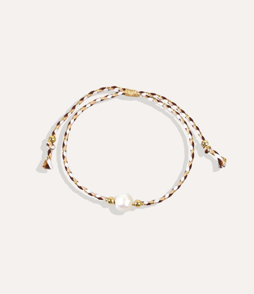 Pearl on a  brown and white string bracelet displayed on a neutral background showcasing its vibrant cord and glossy pearl.