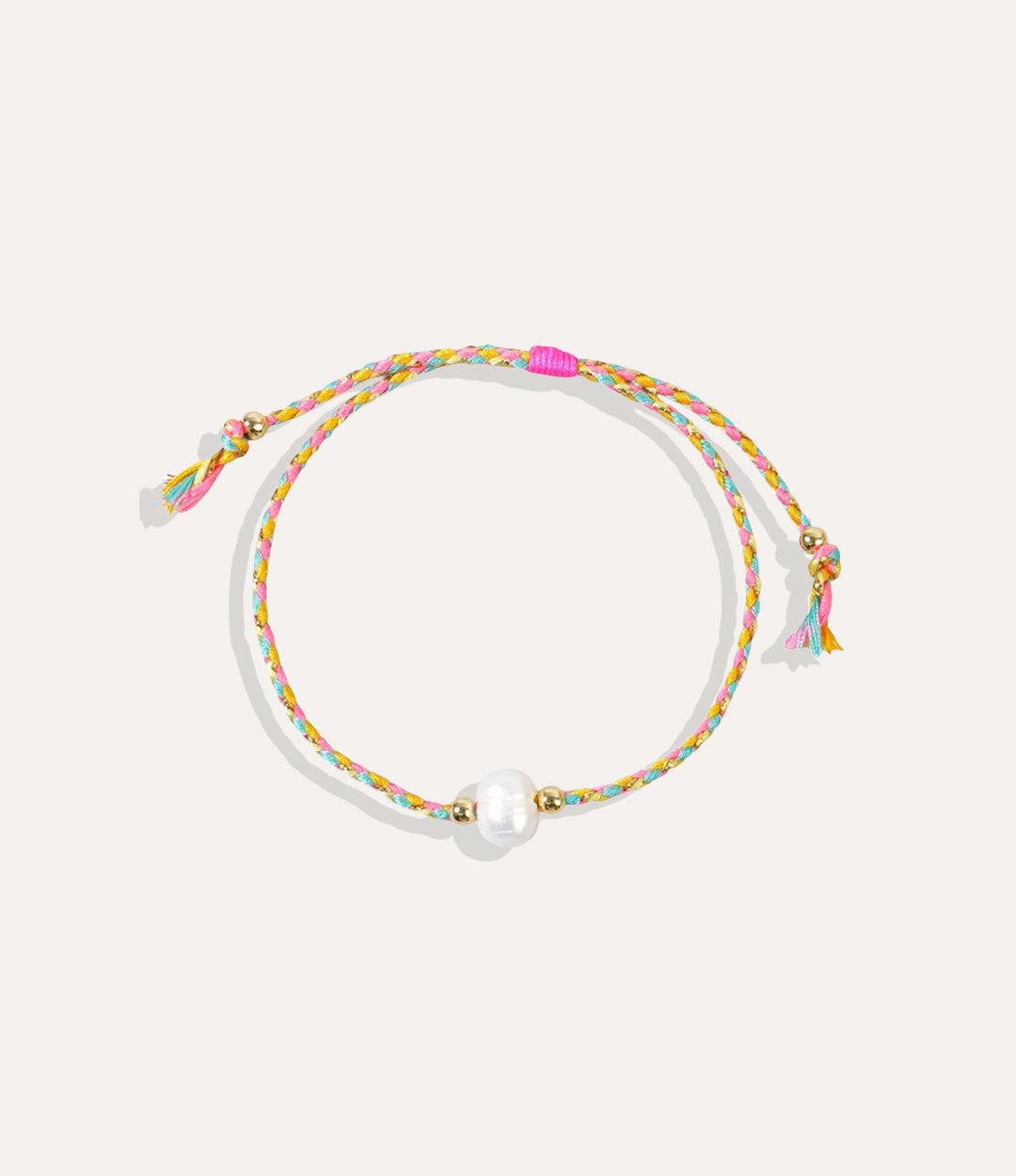 Pearl on a yellow and pink string bracelet displayed on a neutral background showcasing its vibrant cord and glossy pearl.