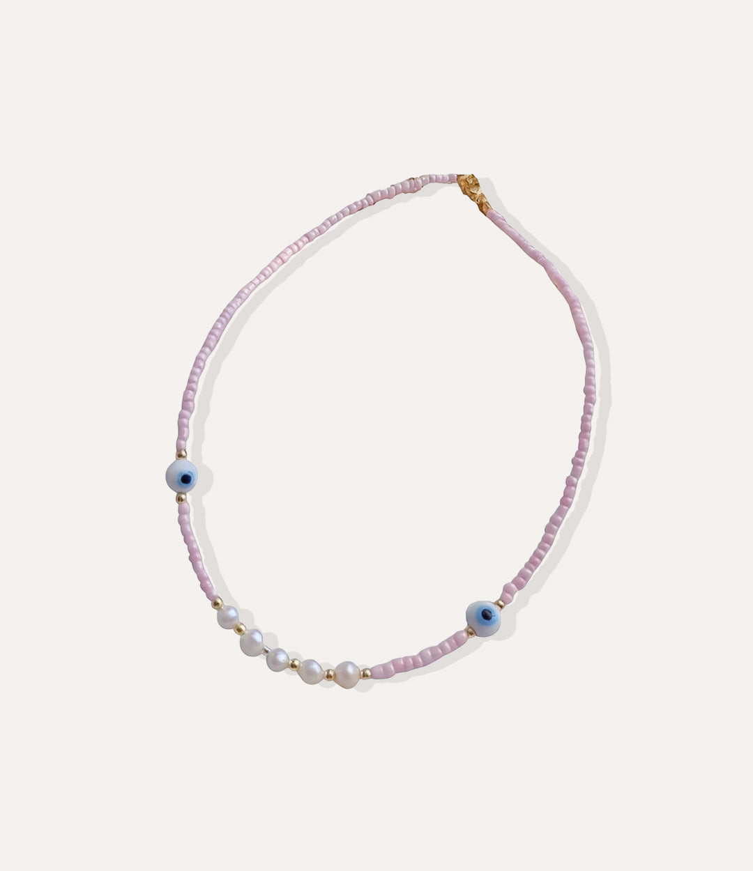 Pink beaded necklace with pearls and evil eye beads displayed in a circle on a white background.