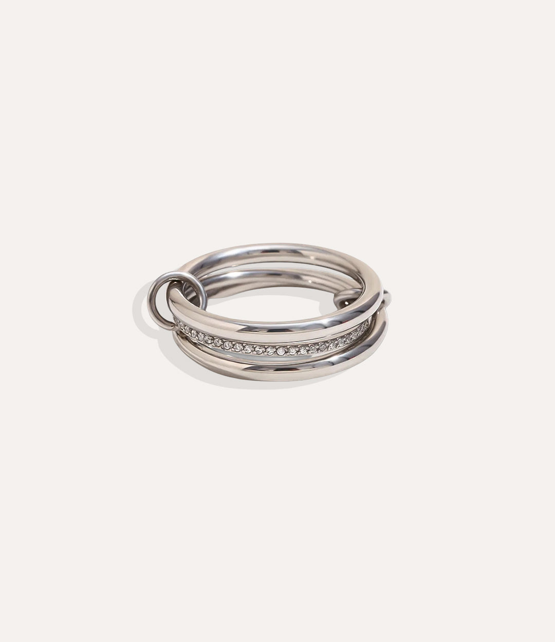 Stack of silver rings with embedded stones on a light gray background