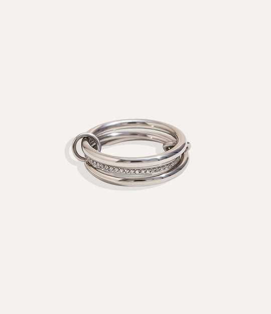Stack of silver rings with embedded stones on a light gray background
