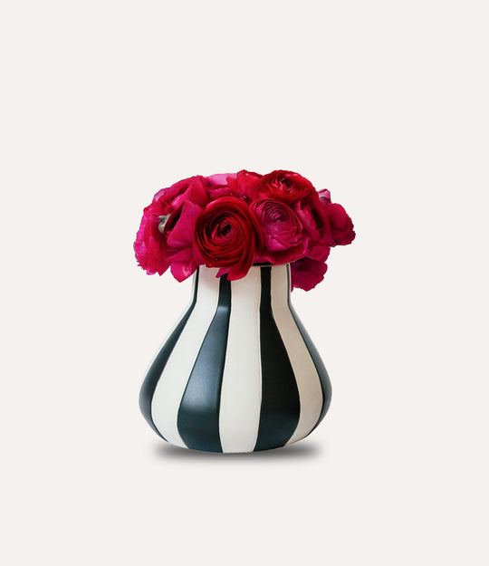 Black and white striped vase with red and pink flowers on a white background