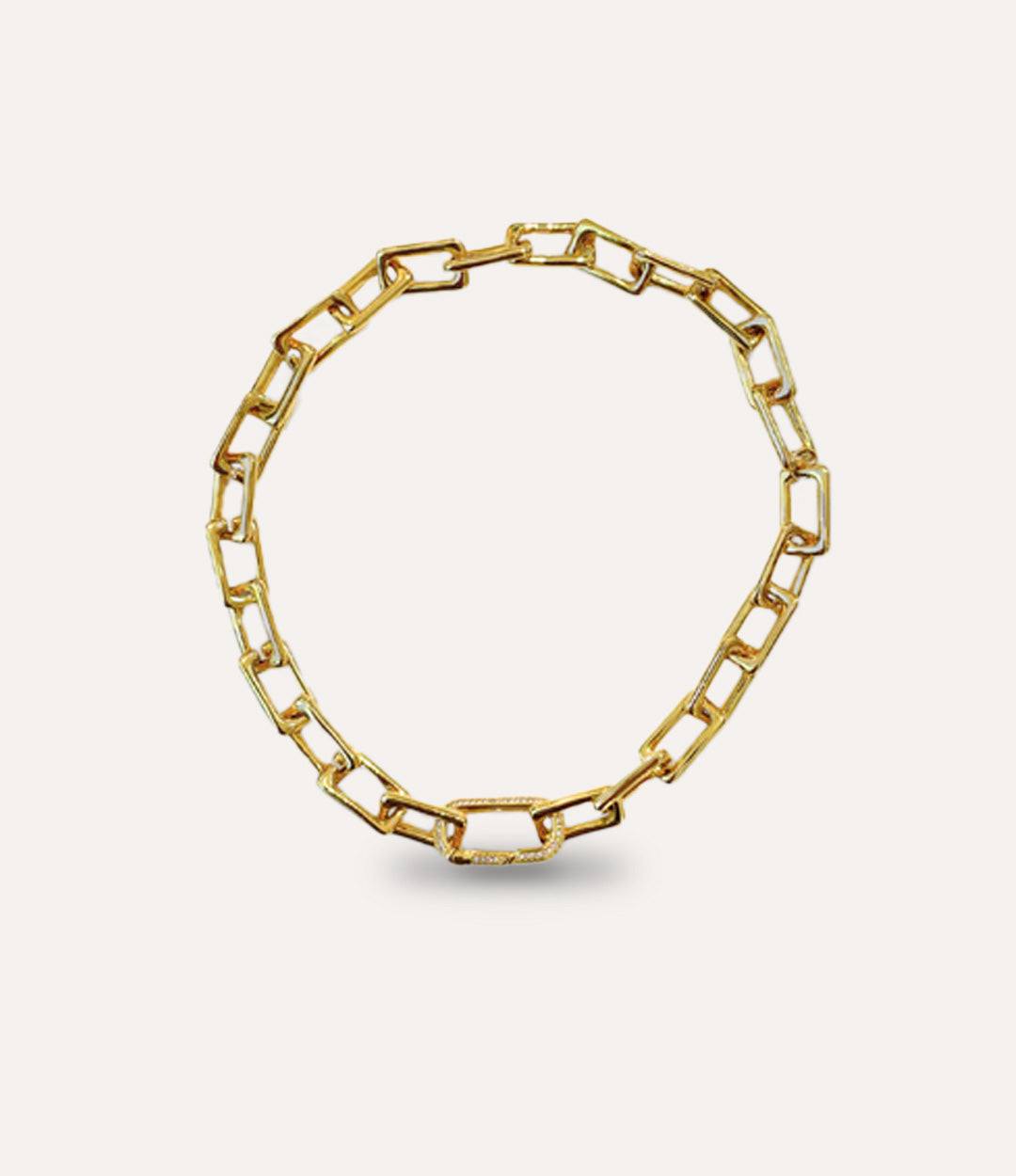 Gold chain necklace on a light beige background