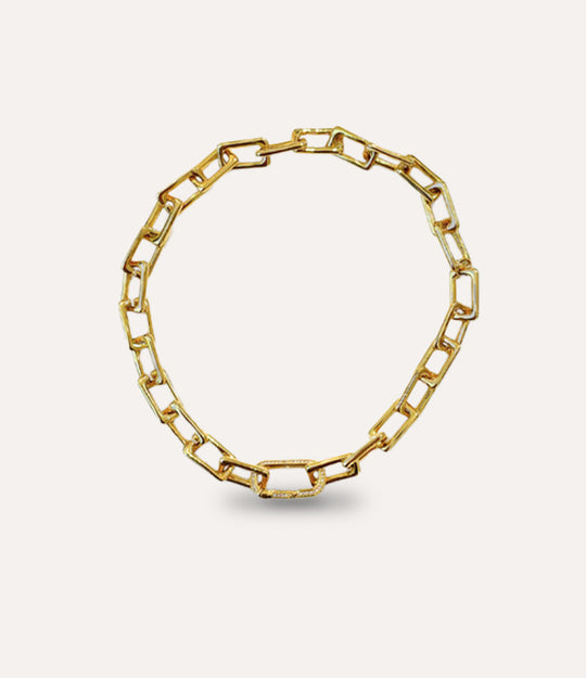 Gold chain necklace on a light beige background