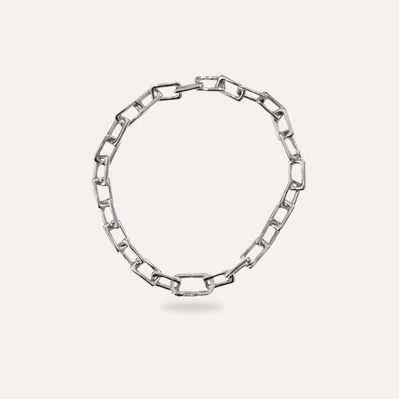 Silver chain necklace on a light gray background