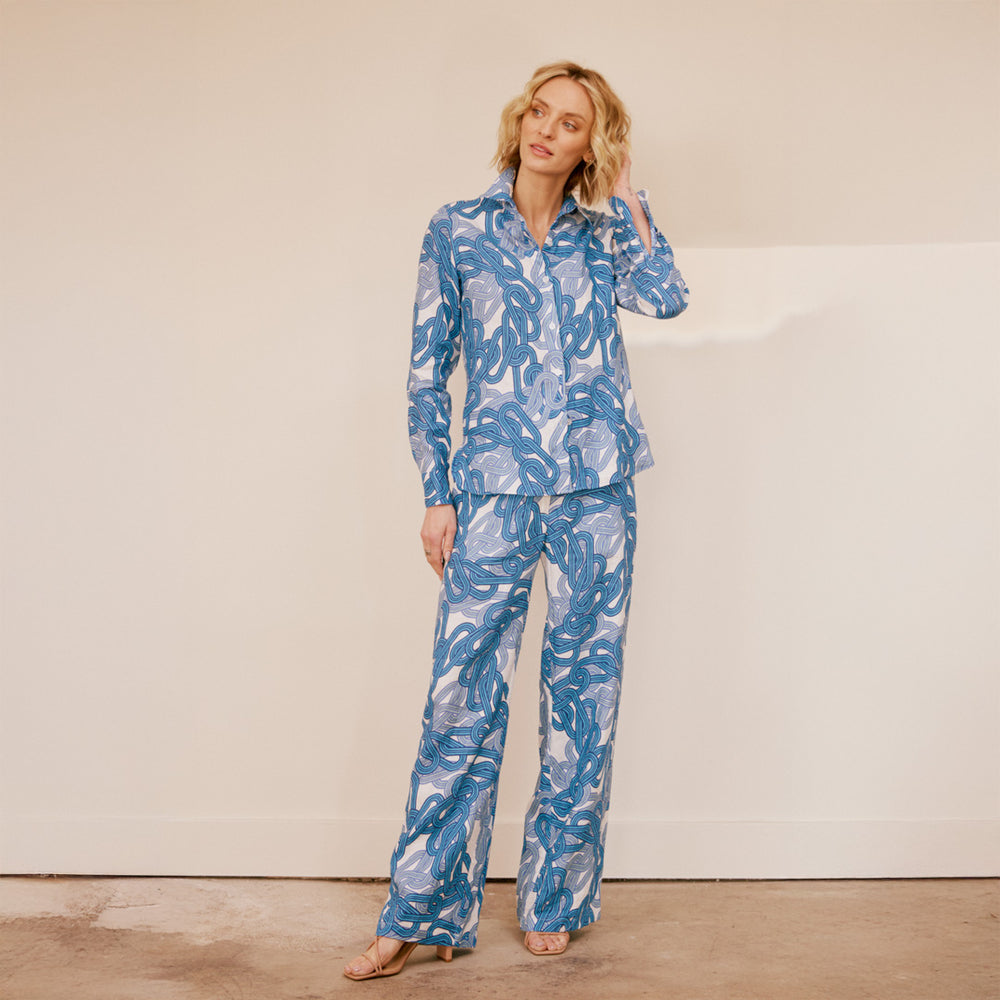 Woman wearing a blue patterned set against a plain background
