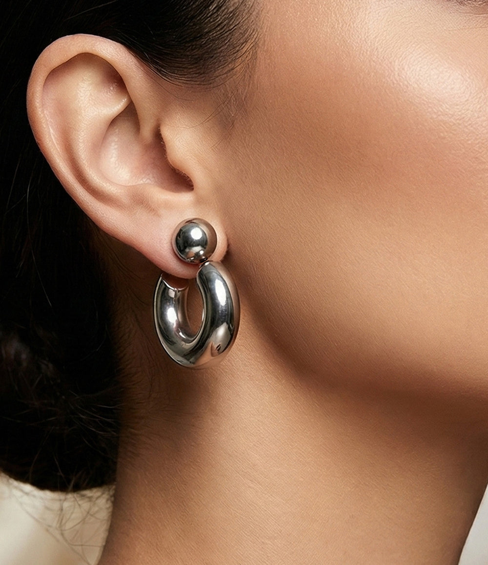 Close-up of a person wearing a silver hoop earring.
