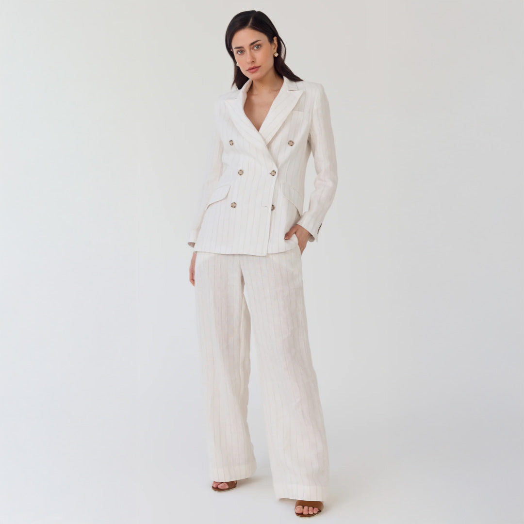 Woman wearing a white suit on a plain background