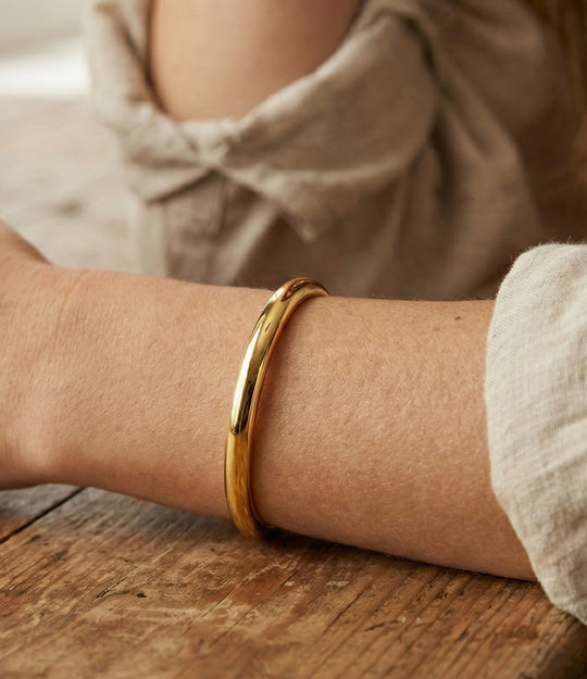 Model wearing layered Skinny Essential Cuffs in gold, showcasing its modern style.