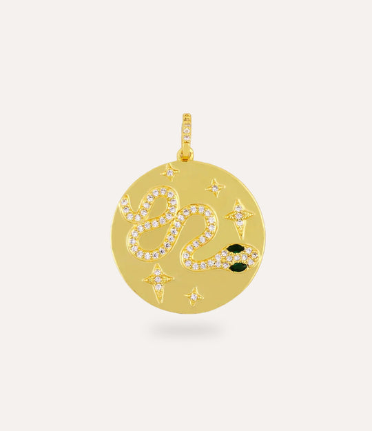 Gold pendant with decorative snake  elements on a light beige background