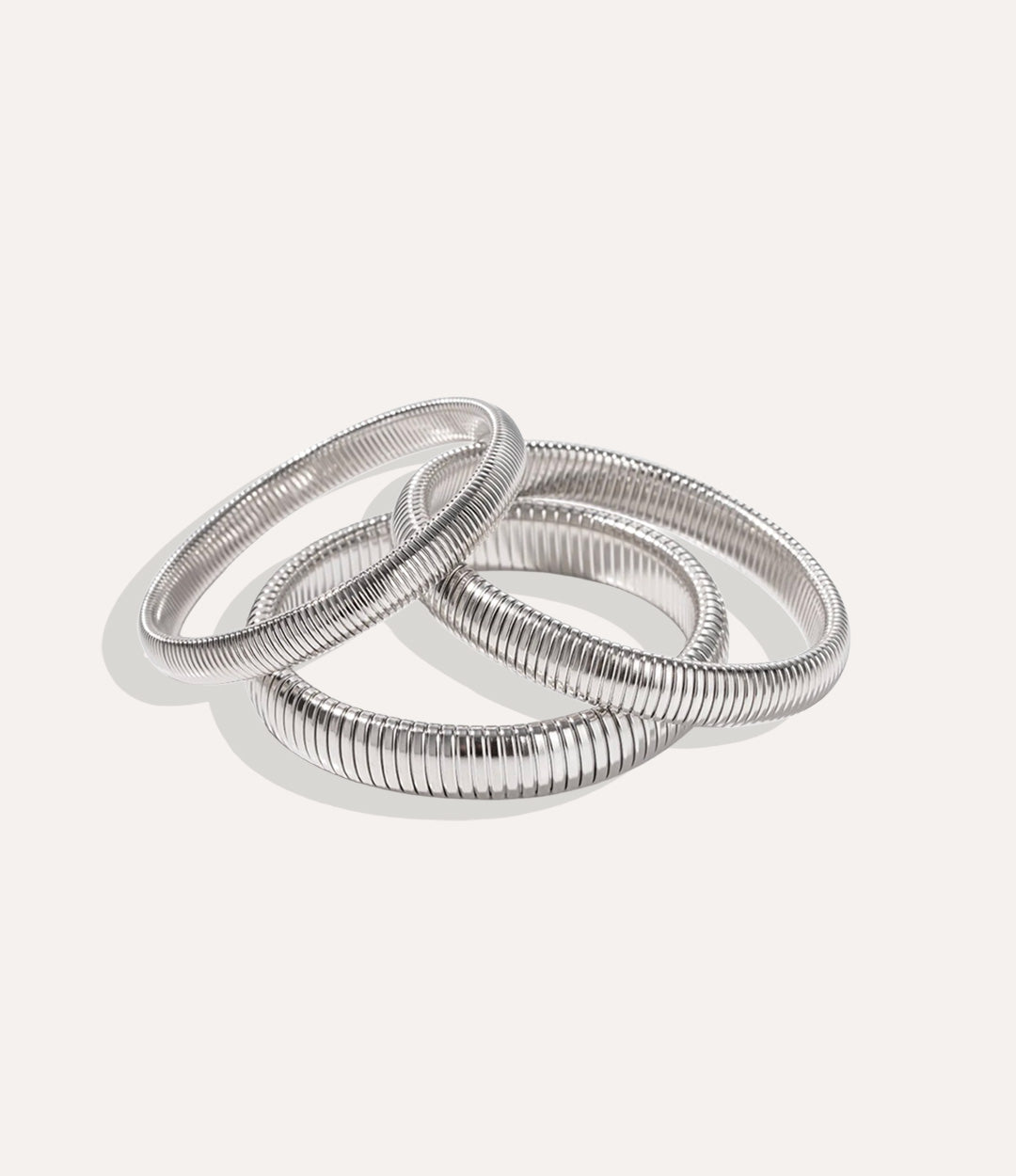 Set of silver bangles on a light gray background