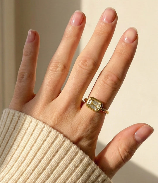 Model wearing the Solitaire Ring in 18k gold plated finish, featuring a single sparkling stone in a vintage setting, isolated on a plain background.