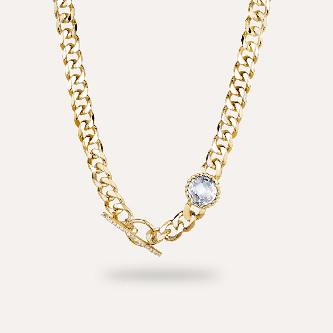 Gold chain necklace with a central white diamond on a white background
