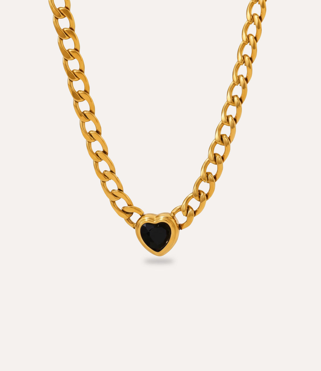 Chunky gold Solitaire Heart Chain Necklace with black heart pendant on neutral background