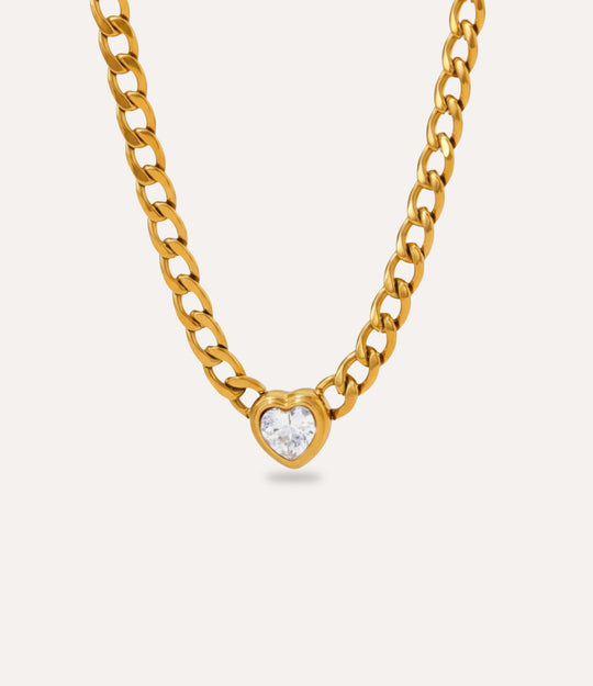 Chunky gold Solitaire Heart Chain Necklace with clear heart pendant on neutral background