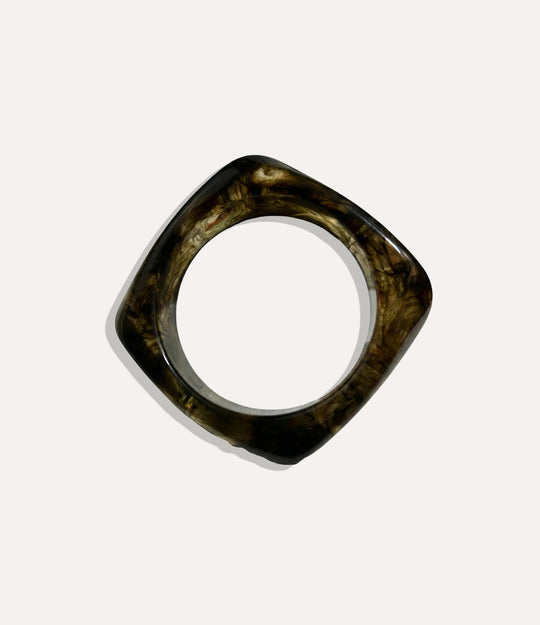 Chunky square bangle made of acrylic and resin in haze colour displayed on a neutral background.