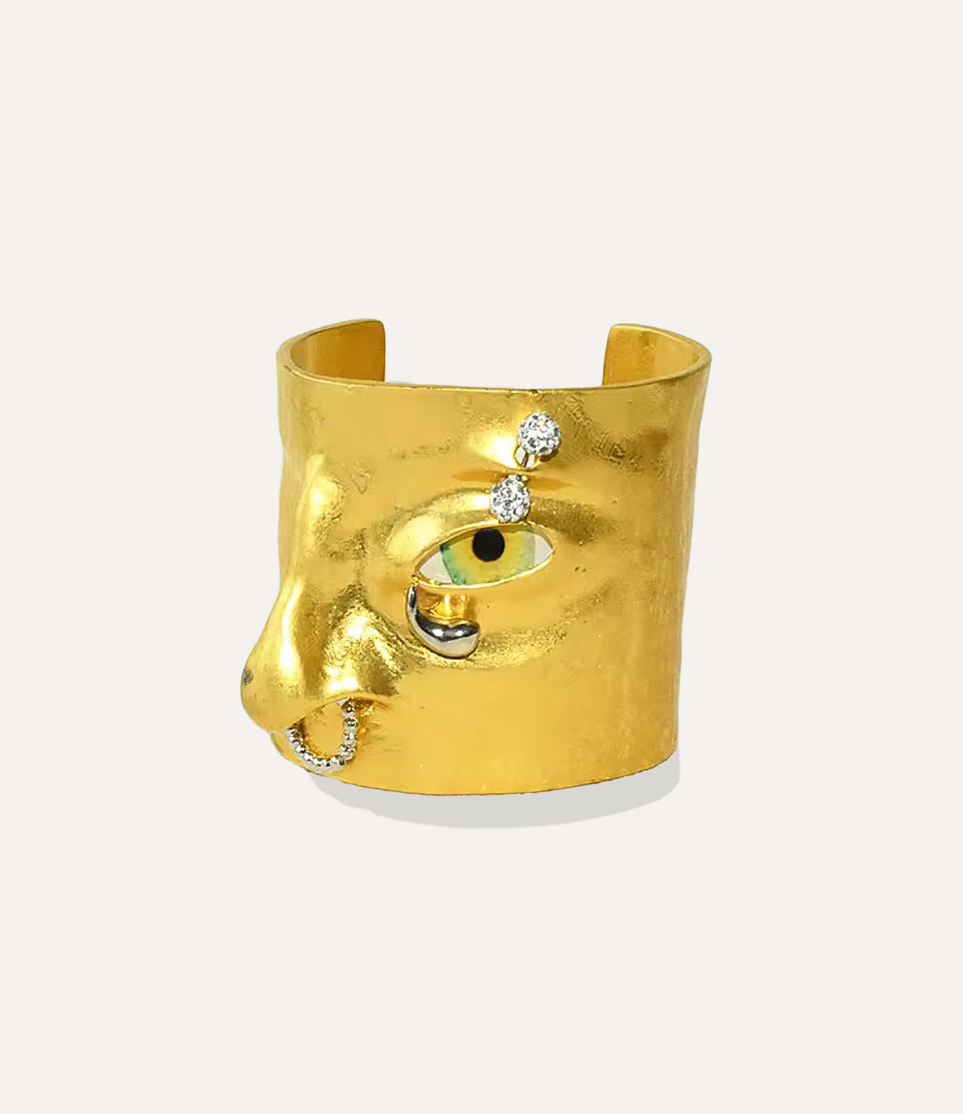 Statement Eye Cuff bracelet featuring a bold face-inspired eye design in gold on a neutral background.
