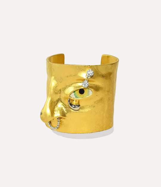 Statement Eye Cuff bracelet featuring a bold face-inspired eye design in gold on a neutral background.
