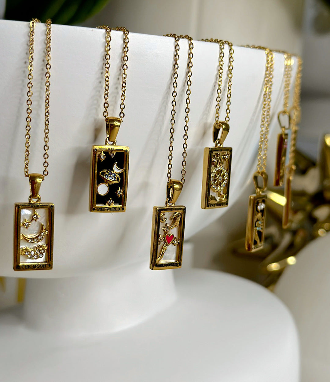 Close-up of 14K gold-plated tarot card necklaces showing engraved card details
