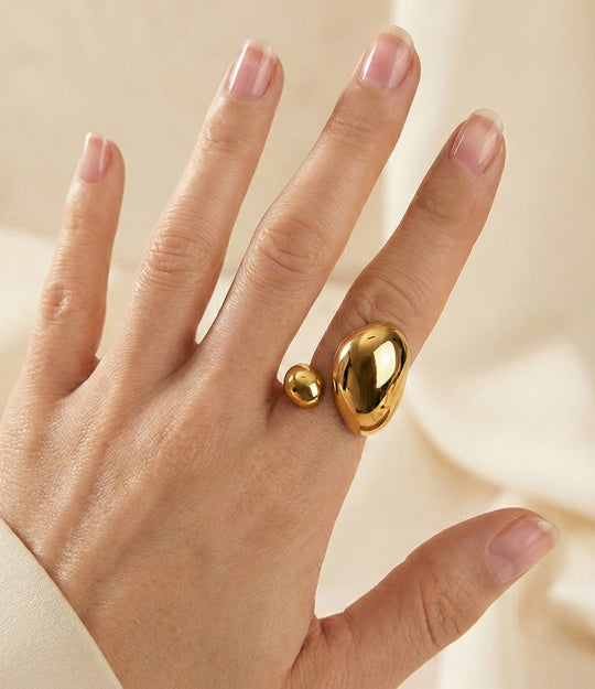 Model wearing the Stella Ring in 18k gold-plated finish, featuring a celestial shooting star motif made of waterproof stainless steel, isolated on a plain backgroun.