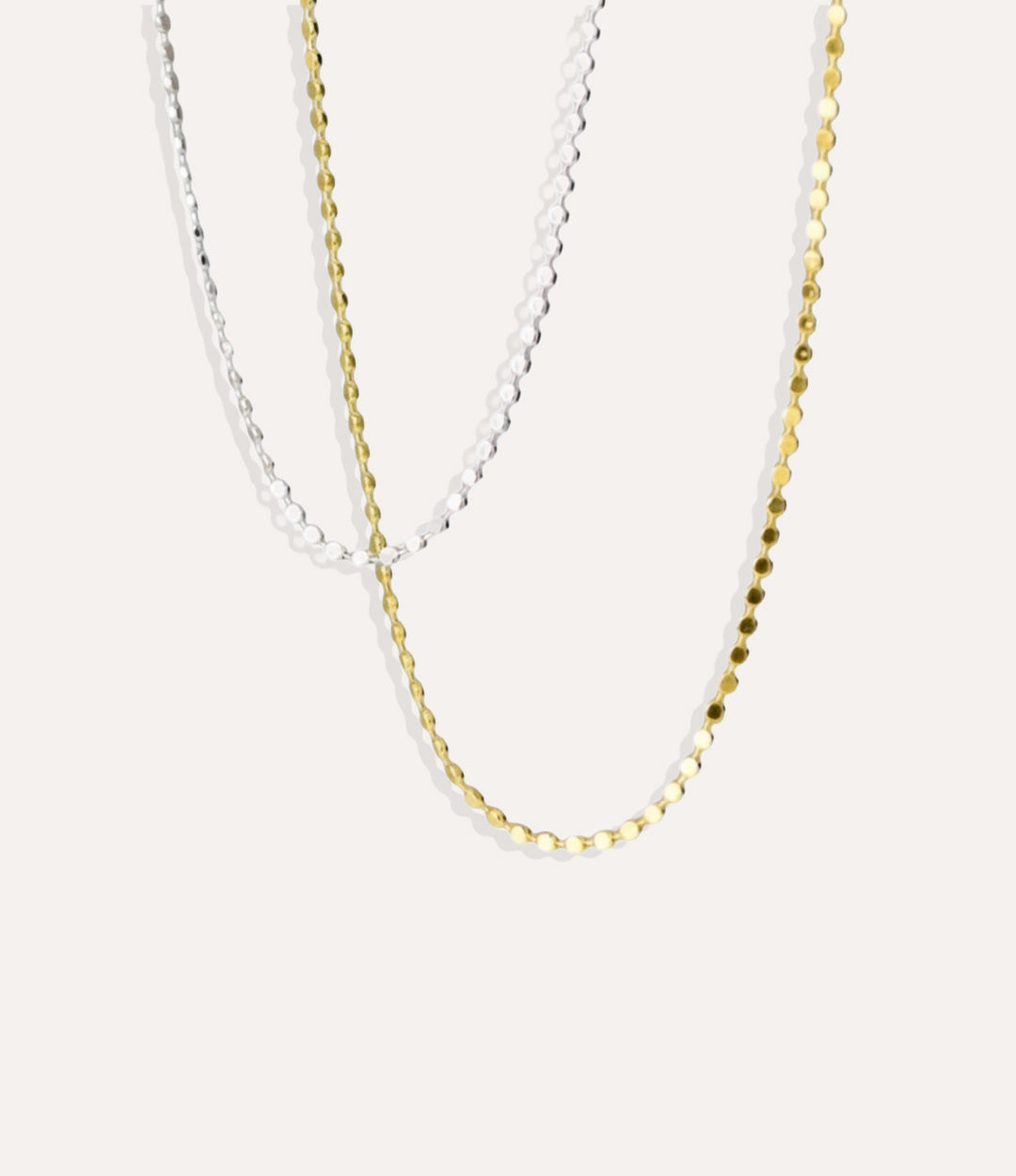 Gold and Silver Disco Chain Necklaces with flat round discs displayed on a neutral background