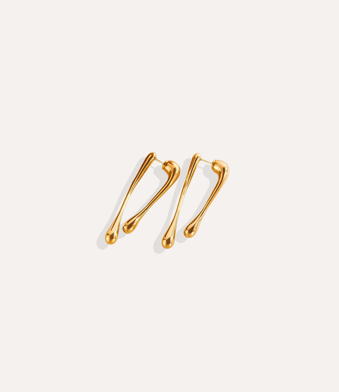 Close up of The Drip Earrings in gold showing the smooth drip shape and 18k gold plating.